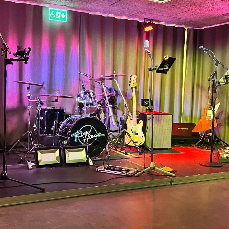 Musikabend im Nuntorp Gård. Bühne mit verschiedenen Musikinstrumenten und farbiger Beleuchtung.
Fotocredit: Sibille Kurdts
@Dalslandliebe